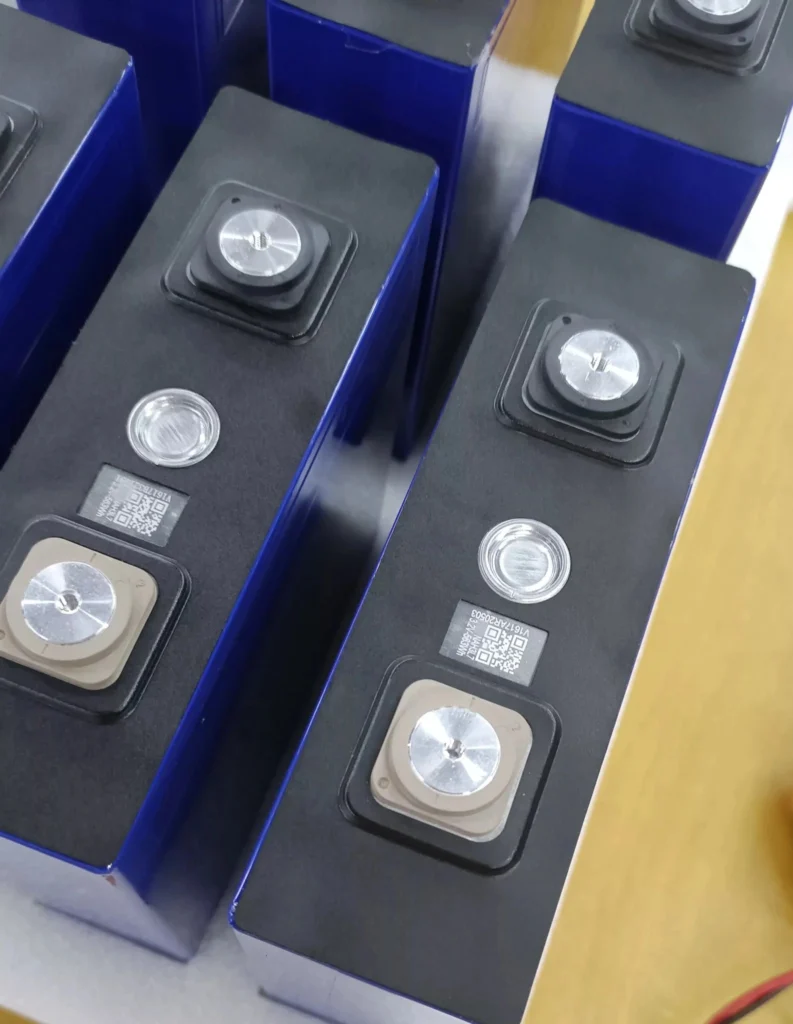 Close-up of fresh CALB L173F230 Grade A LiFePO4 cells in original blue aluminum shells, showcasing laser-engraved QR codes for full traceability and 736Wh energy density per cell.